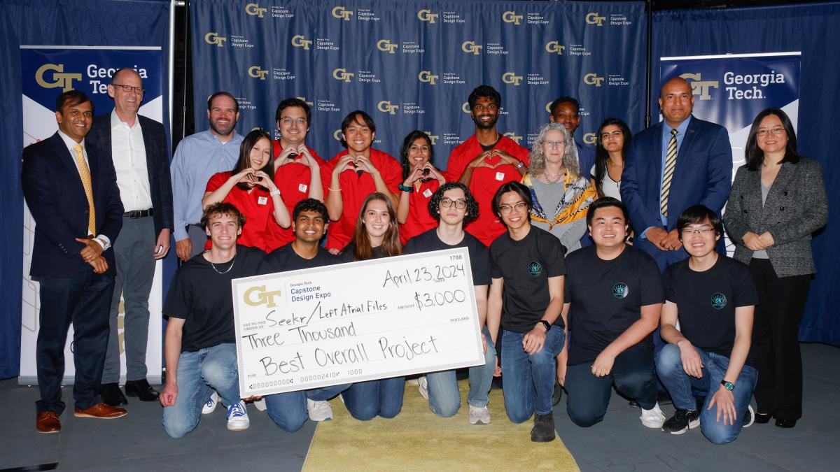 students and College leaders posing with winning check